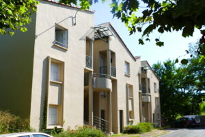 photo d’habitation cité de l’embouage photo de 3 habitations identiques collées les unes aux autres. Elles possèdent 2 étages et sont légèrement entourées de plantes situées cité de l'embouage